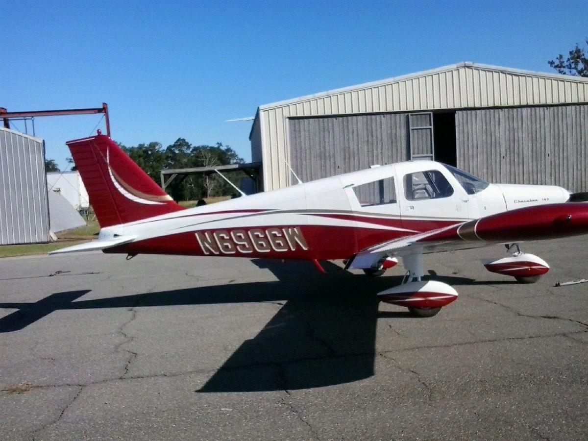 Piper Cherokee in a red-and-white sweep scheme on the ramp