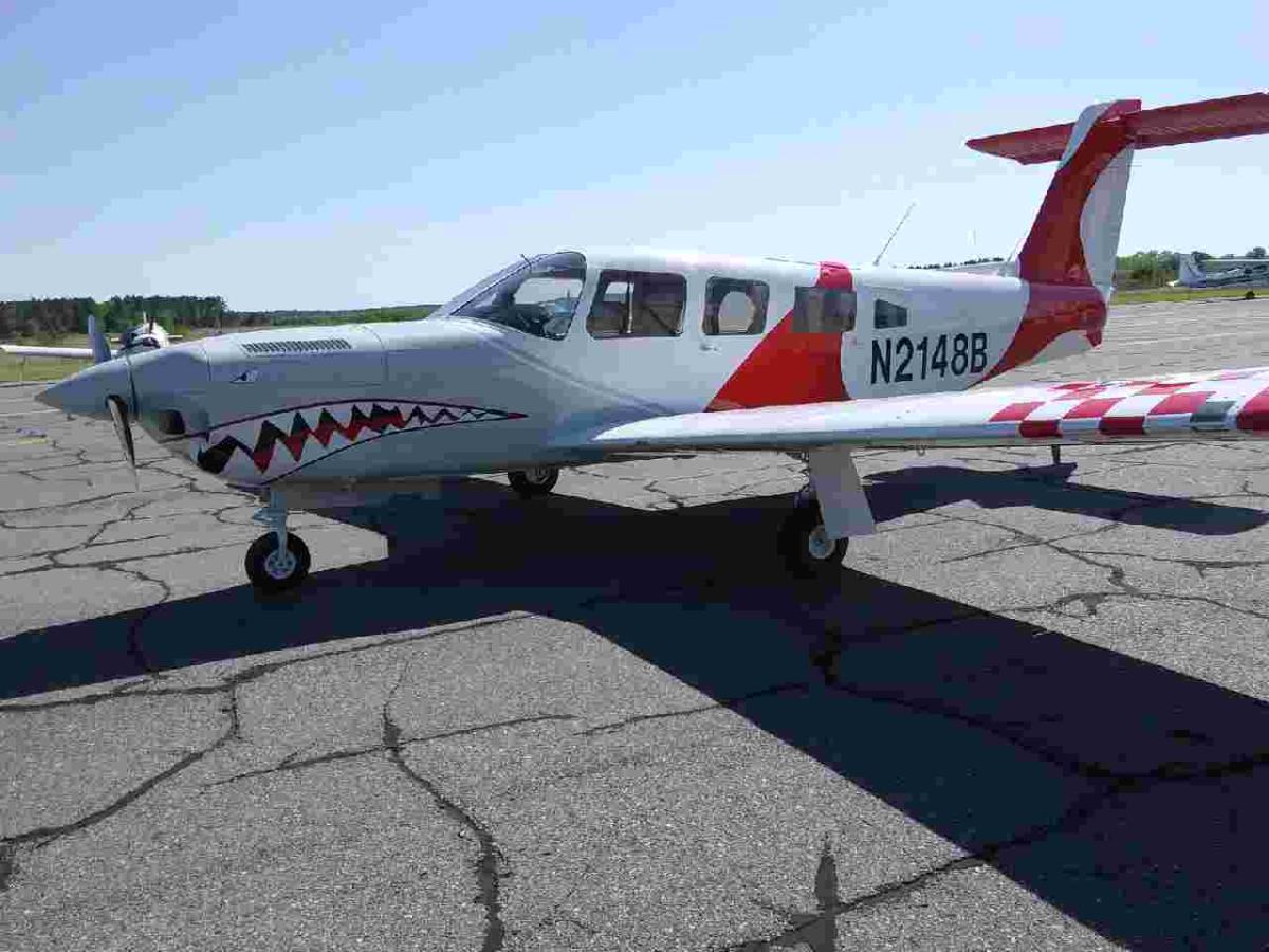 Twin Piper with a shark-mouth nose and red-checked wingtips