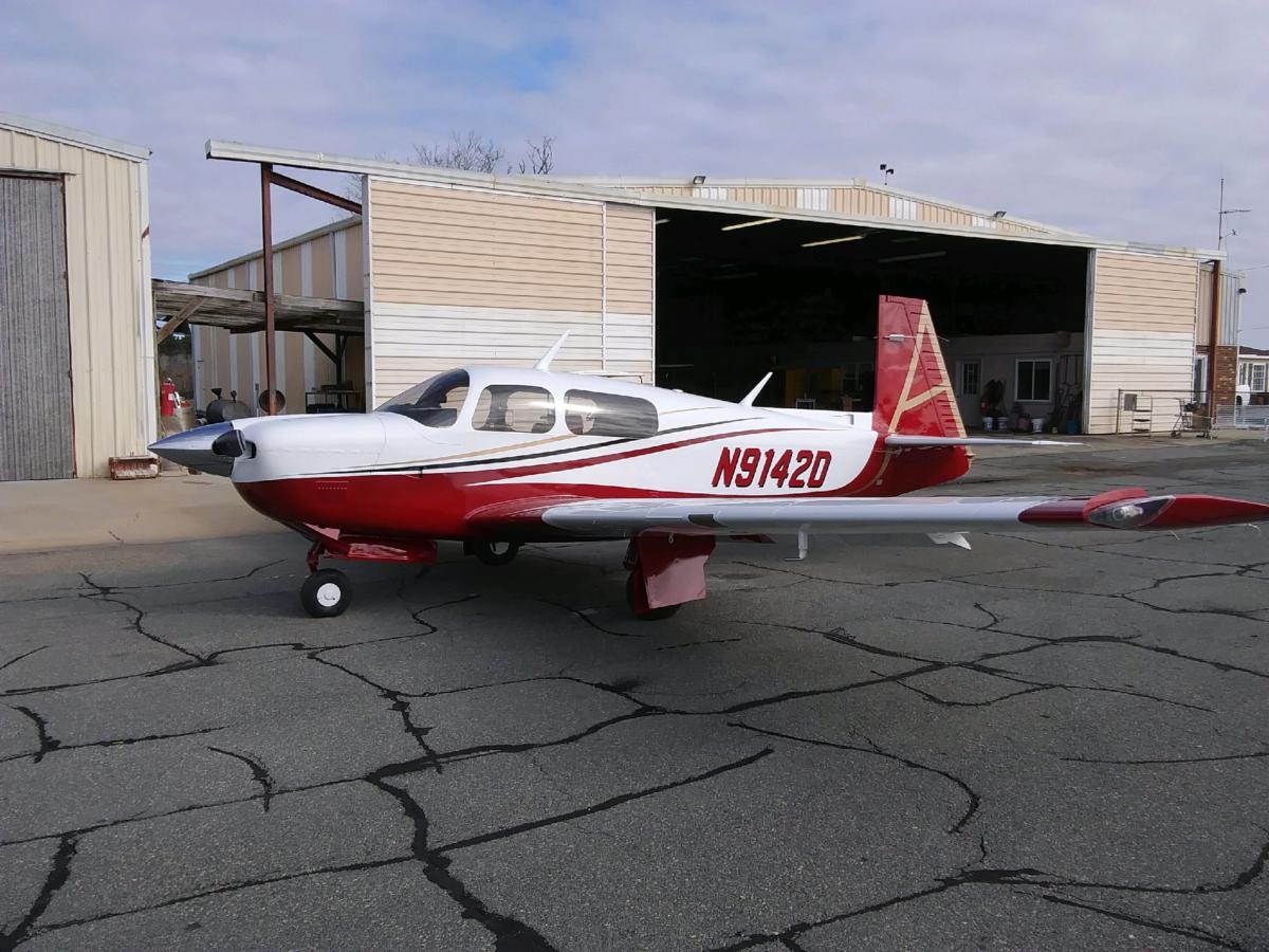 Cessna in a fresh paint scheme parked by the shop