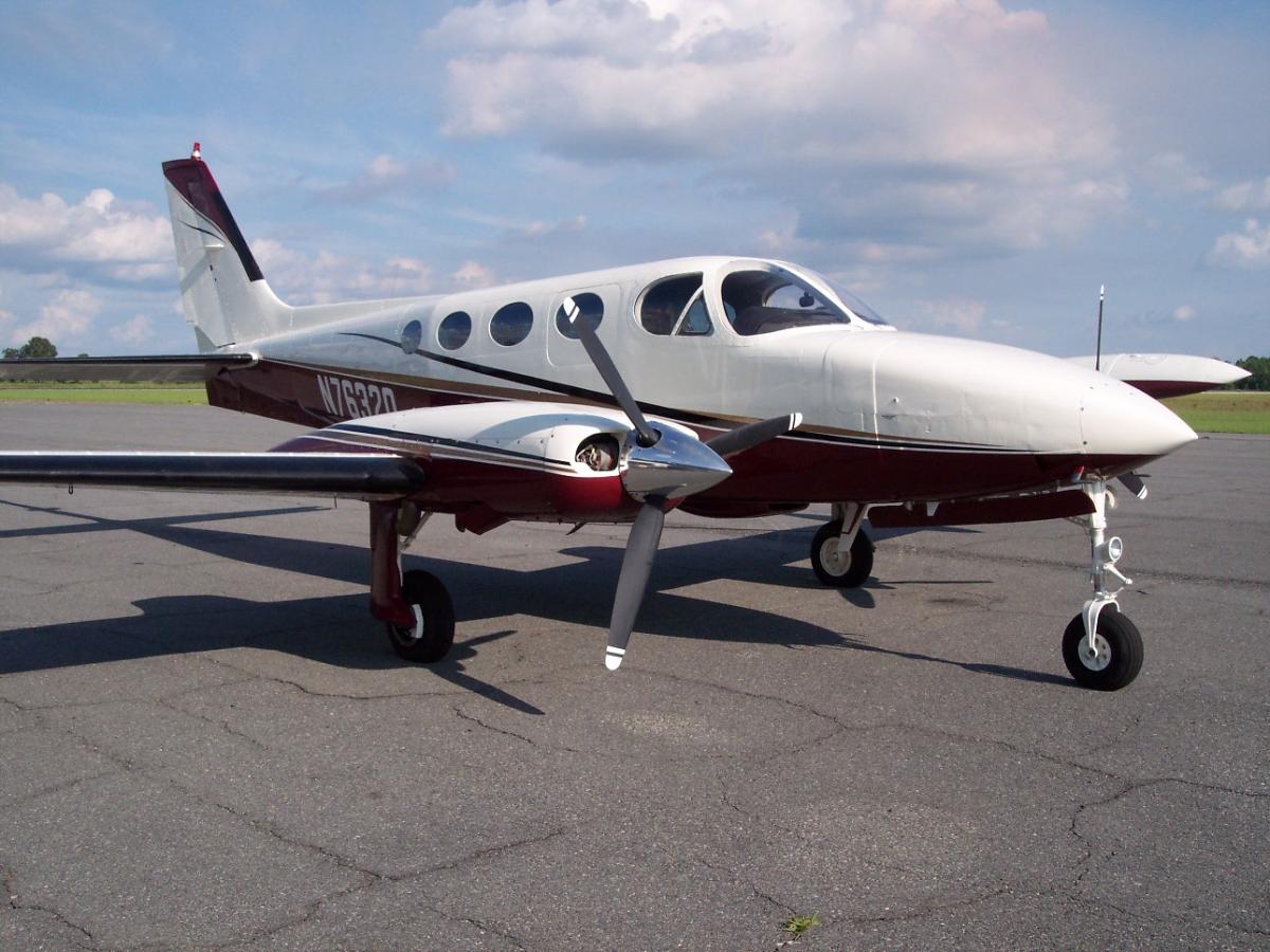 Cessna 340 twin in white with a maroon and gold belly stripe