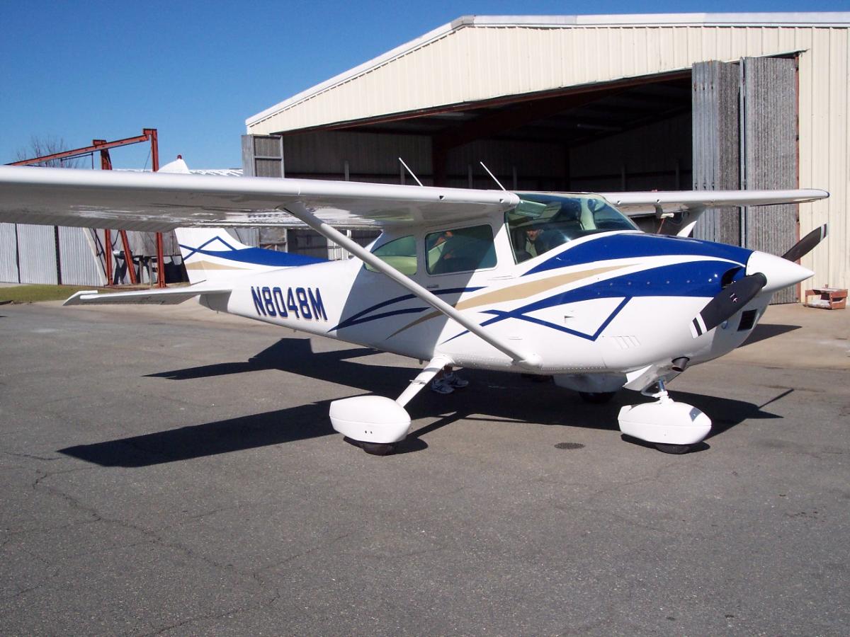 Single-engine aircraft freshly painted outside the hangars
